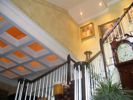 open coffered ceiling, faux finished sky above (with spercialty lighting.) Wall finish & crown moulding.